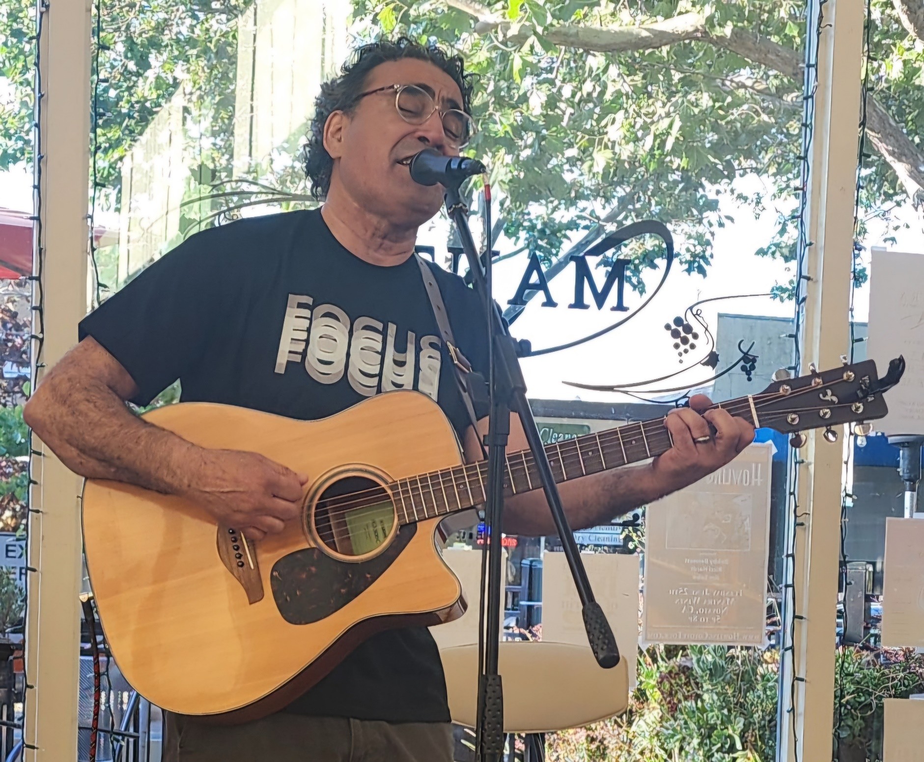 rOjO singing and playing acoustic guitar during a live performance